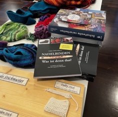 Arbeitstisch mit Buch und Materialien zum Nadelbinden