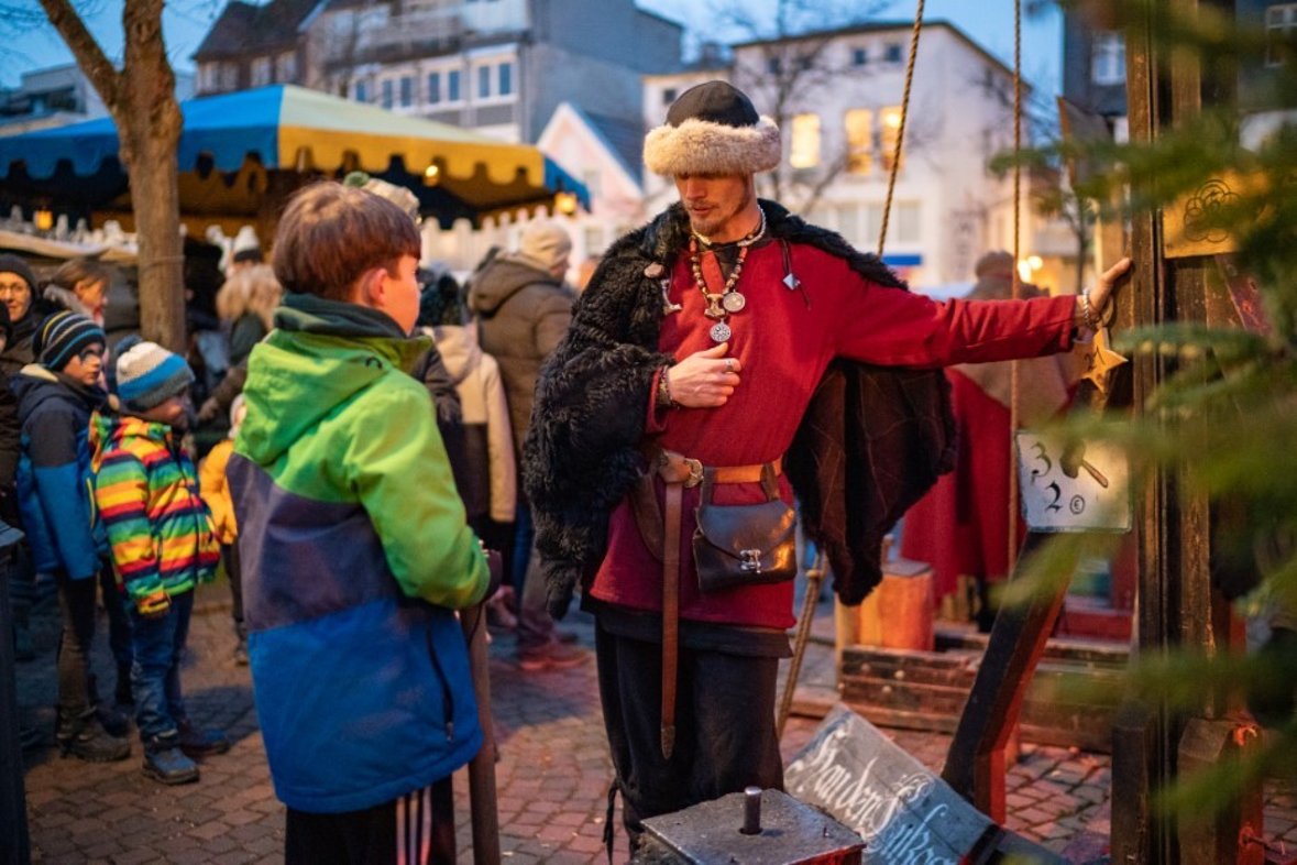 Mittelalterlicher Krämer in Gespräch mit Jungen