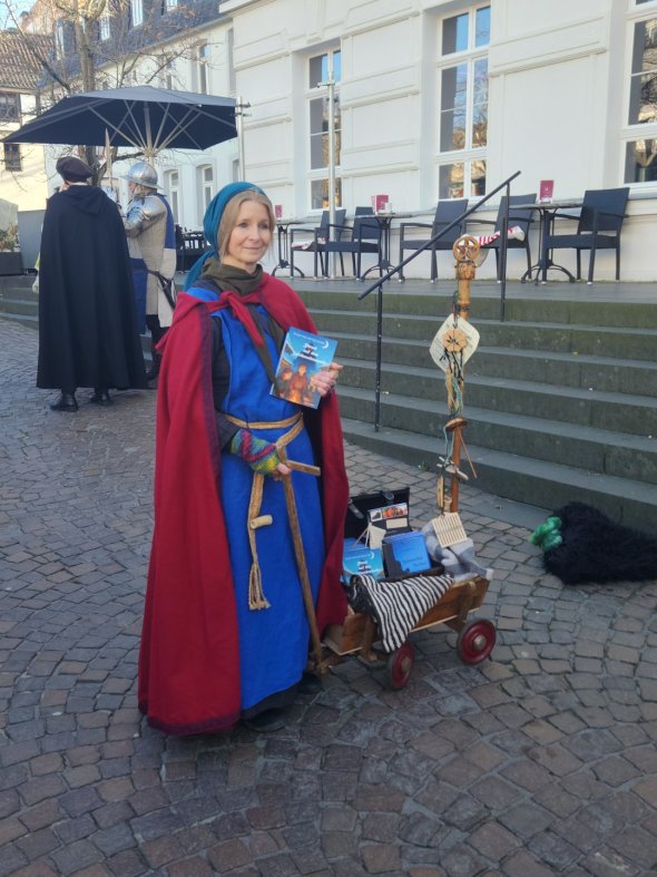 Rätsel auf dem Mittelaltermarkt Ulrike Claßen Büttner mit dem Buch zum Markt