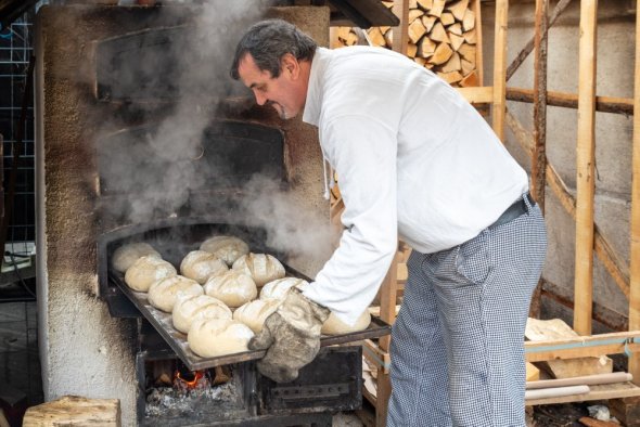 Der Bäcker schiebt das Brot in den Ofen