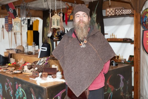 Mann am Stand mit Holzspielzeug